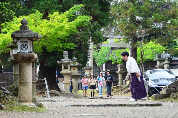 Japonia, Kyoto, mężczyzna kłania się w stronę odjeżdżającego samochodu swoich gości